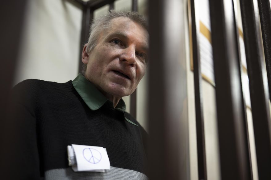 Imprisoned Kremlin critic Alexei Gorinov, stands in a cage at the court as his second trial for criticizing Russia's actions in Ukraine swiftly nears its conclusion in Vladimir, Russia, Friday, Nov. 29, 2024. (AP Photo/Dmitry Serebryakov)