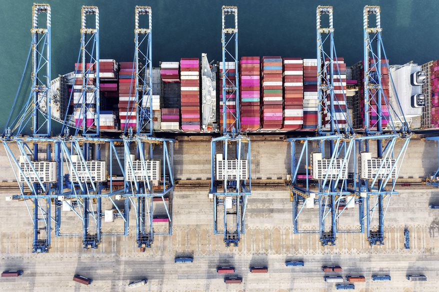 Aerial view of cranes and a ship at a container terminal in Qingdao city in east China's Shandong province Tuesday, Dec. 10, 2024. (Chinatopix Via AP)