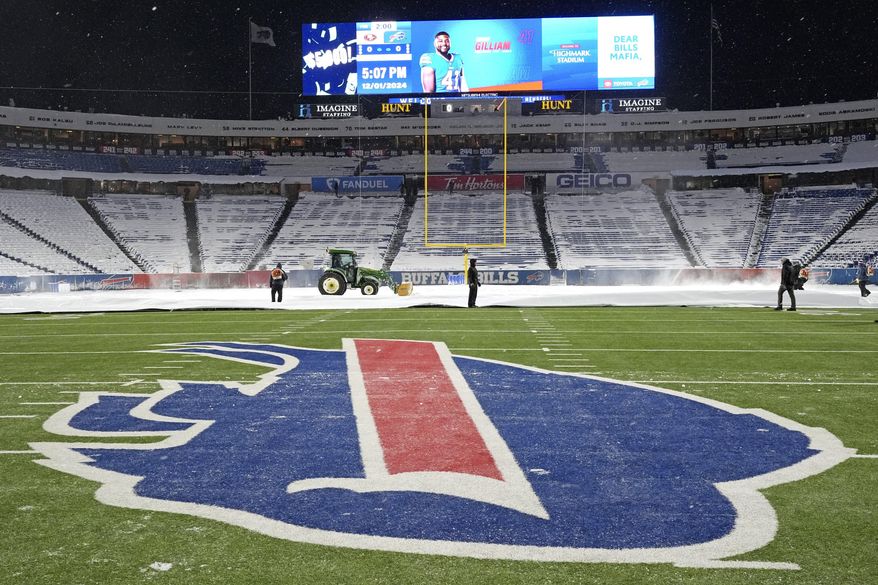 Workers clear snow in Highmark Stadium in preparation for a Sunday Night Football game between the Buffalo Bills and the San Francisco 49ers in Orchard Park, N.Y., Sunday, Dec. 1, 2024. (AP Photo/Gene J. Puskar)