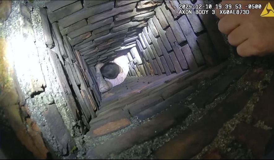 This image provided by City of Fall River Police Department shows police encounter of a man attempting to evade arrest by hiding inside a chimney on Tuesday, Dec. 10, 2024 in Fall River, Mass. (City of Fall River Police Department via AP)