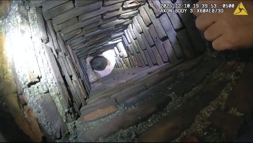 This image provided by City of Fall River Police Department shows police encounter of a man attempting to evade arrest by hiding inside a chimney on Tuesday, Dec. 10, 2024 in Fall River, Mass. (City of Fall River Police Department via AP)