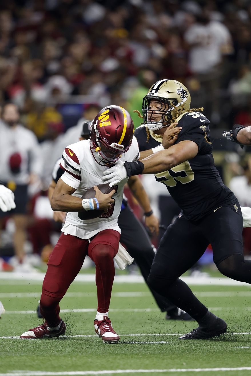 Washington Commanders quarterback Jayden Daniels (5) is sacked by New Orleans Saints defensive end Chase Young (99) during an NFL football game, Sunday, Dec. 15, 2024, in New Orleans. (AP Photo/Tyler Kaufman)