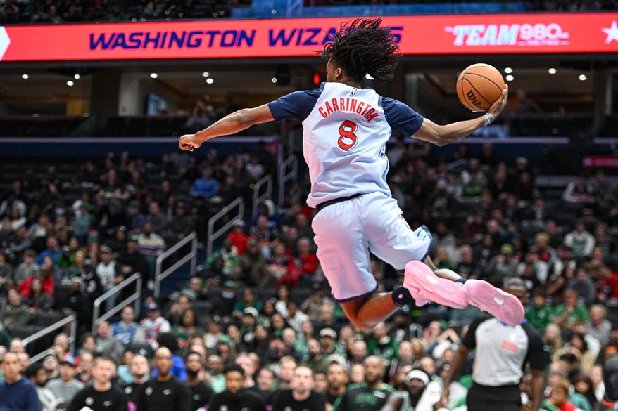 Washington Wizards guard Bub Carrington (8) jumping to save the ball from going out of bounds during the fourth quarter of an NBA game against the Boston Celtics at Capital One Arena in Washington D.C., December 15, 2024. (Photo for the Washington Times)