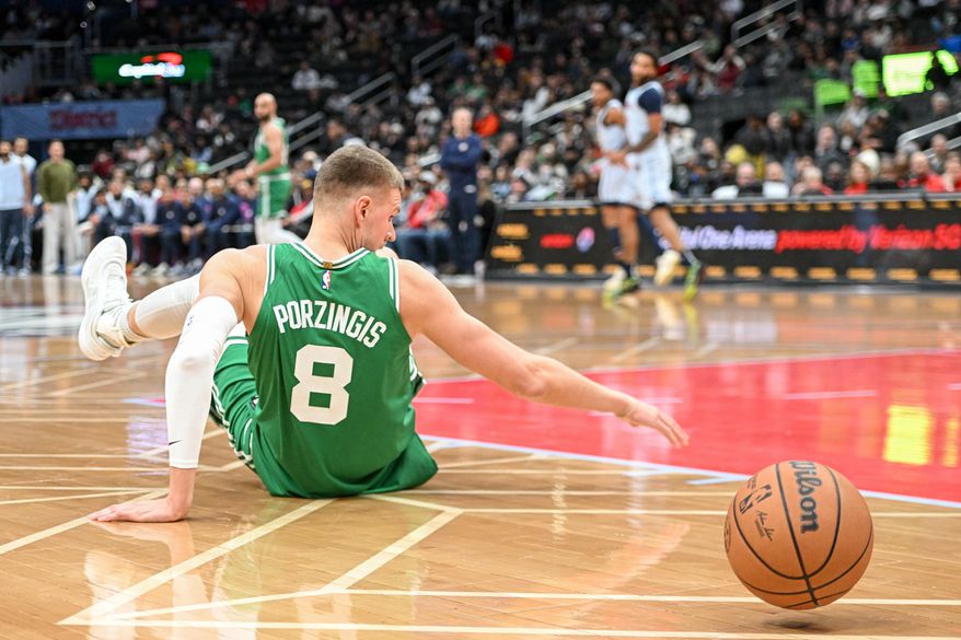 Boston Celtics center Kristaps Porzingis (8) reaching for a loose ball during the first quarter of an NBA game against the Washington Wizards at Capital One Arena in Washington D.C., December 15, 2024. (Photo for the Washington Times)