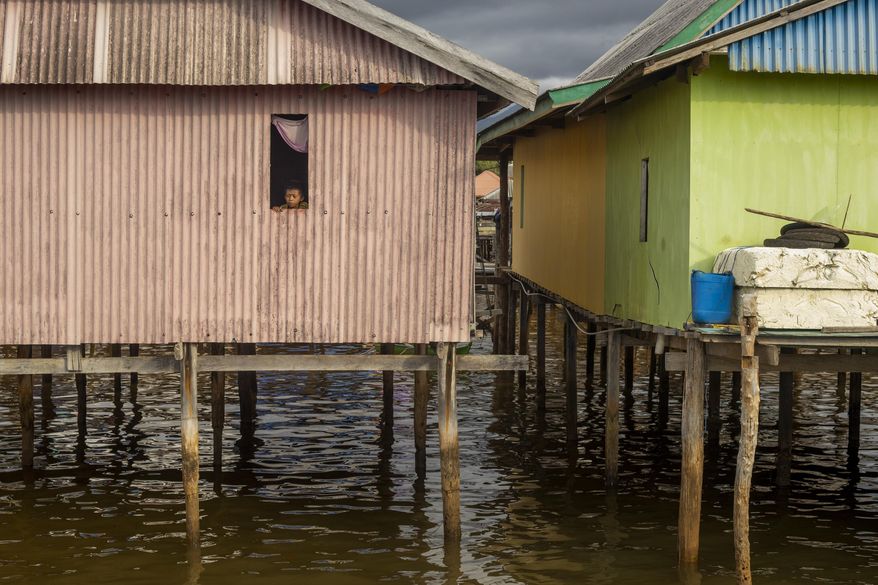 A boy looks out from the window of his house on Kabaena Island in South Sulawesi, Indonesia, Friday, Nov. 15, 2024. (AP Photo/Yusuf Wahil)