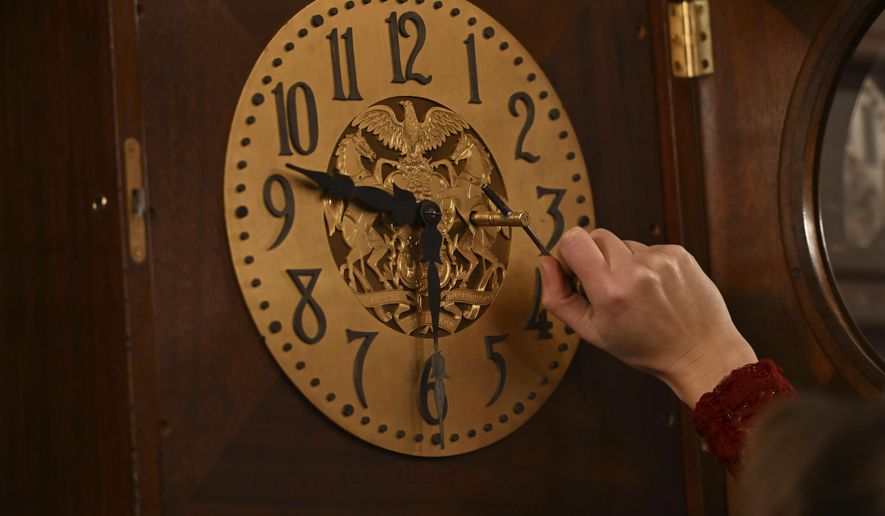 Bethany Gill winds a clock in the Pennsylvania Supreme Court chamber, Dec. 13, 2024, in Harrisburg, Pa. It's one of 273 clocks in Pennsylvania's ornate state Capitol complex buildings that must be wound by hand. (AP Photo/Marc Levy)