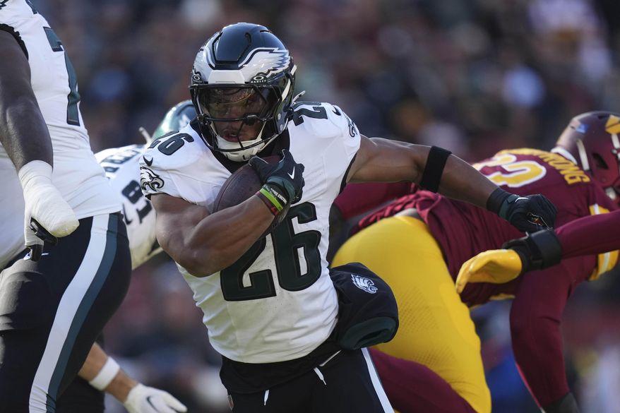 Philadelphia Eagles running back Saquon Barkley (26) running with the ball during the first half of an NFL football game against the Washington Commanders, Sunday, Dec. 22, 2024, in Landover, Md. (AP Photo/Stephanie Scarbrough)