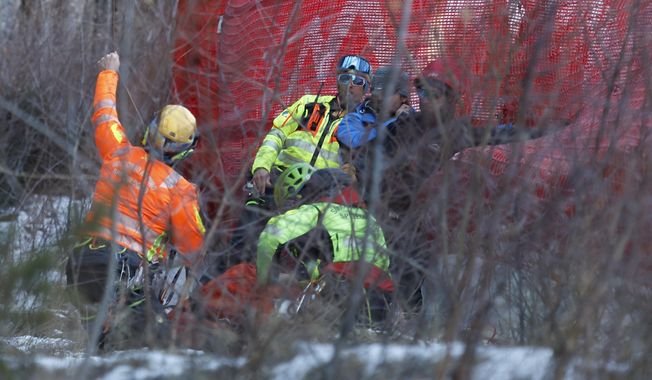 Medical staff are helping France's Cyprien Sarrazin after crashing into protections net during an alpine ski, men's World Cup downhill training, in Bormio, Italy, Friday, Dec. 27, 2024. (AP Photo/Alessandro Trovati)
