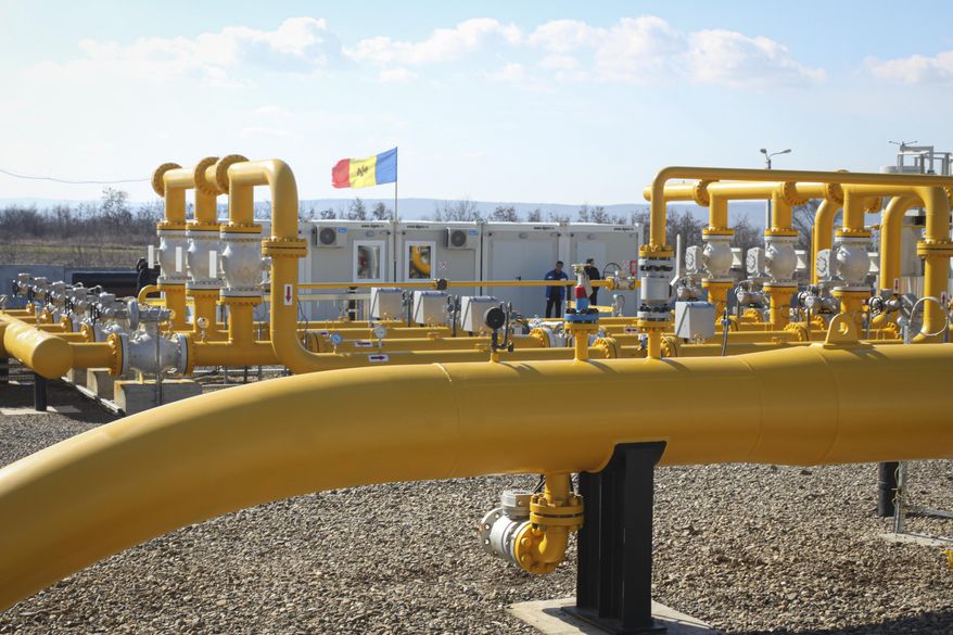 Men stand next to pipelines of the national natural gas distribution network outside Ungheni, Moldova, March 4, 2015. (AP Photo/Aurel Obreja, File)