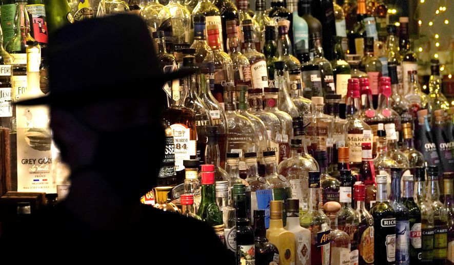 Bottles of alcohol sit on shelves at a bar in Houston, June 23, 2020. (AP Photo/David J. Phillip, File)