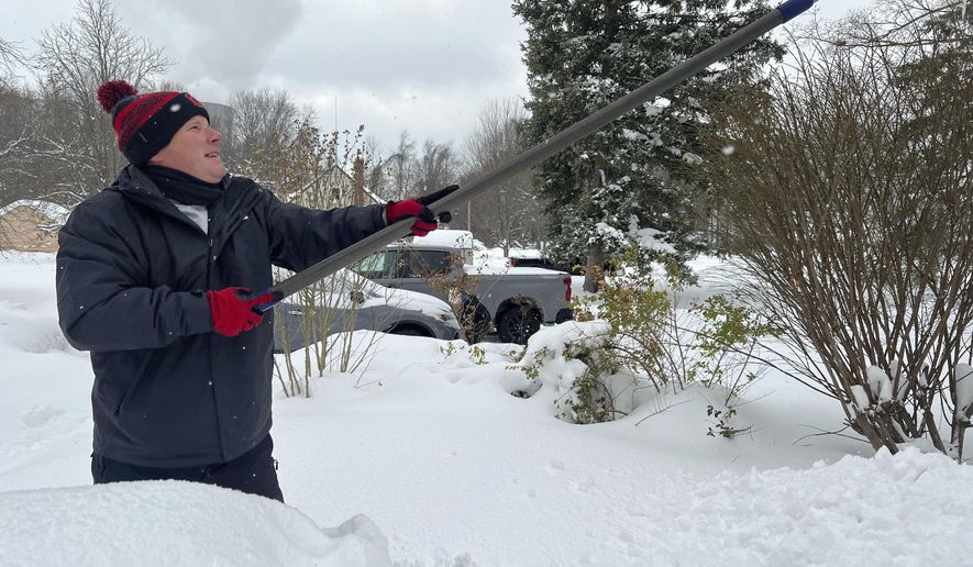 Resident Todd Brainard cleans snow off of the roof of his home in North Perry, Ohio on Tuesday, Dec. 3, 2024. (AP Photo/Patrick Aftoora-Orsagos, File)