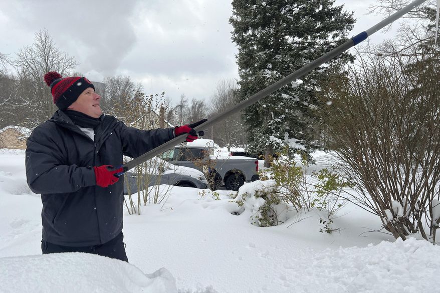 Resident Todd Brainard cleans snow off of the roof of his home in North Perry, Ohio on Tuesday, Dec. 3, 2024. (AP Photo/Patrick Aftoora-Orsagos, File)