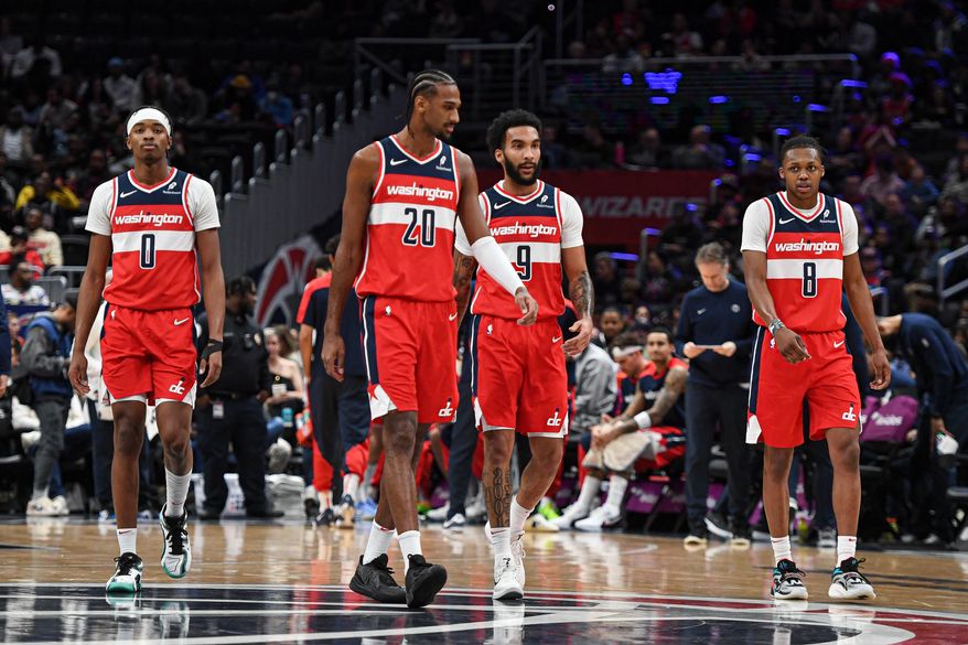 Washington Wizards players Bilal Coulibaly (0), Alex Sarr (20), Justin Champagnie (9) and Bub Carrington (8) walk back onto the floor after a timeout during the first quarter of an NBA game against the Chicago Bulls at Capital One Arena in Washington D.C., January 1, 2025. (Photo for the Washington Times)