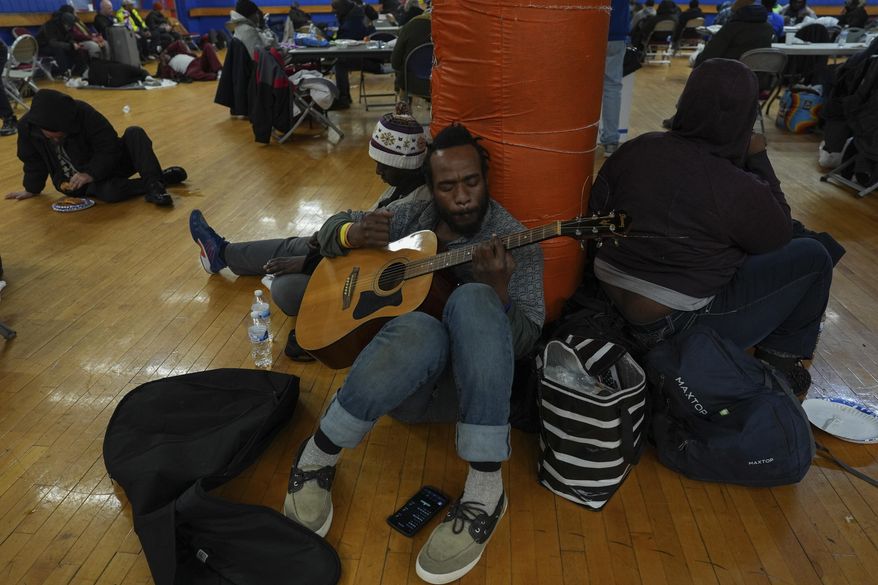 Tirrdell Byrd plays guitar while sheltering from the cold inside a recreation center, Monday, Jan. 6, 2025, in Cincinnati. (AP Photo/Joshua A. Bickel)