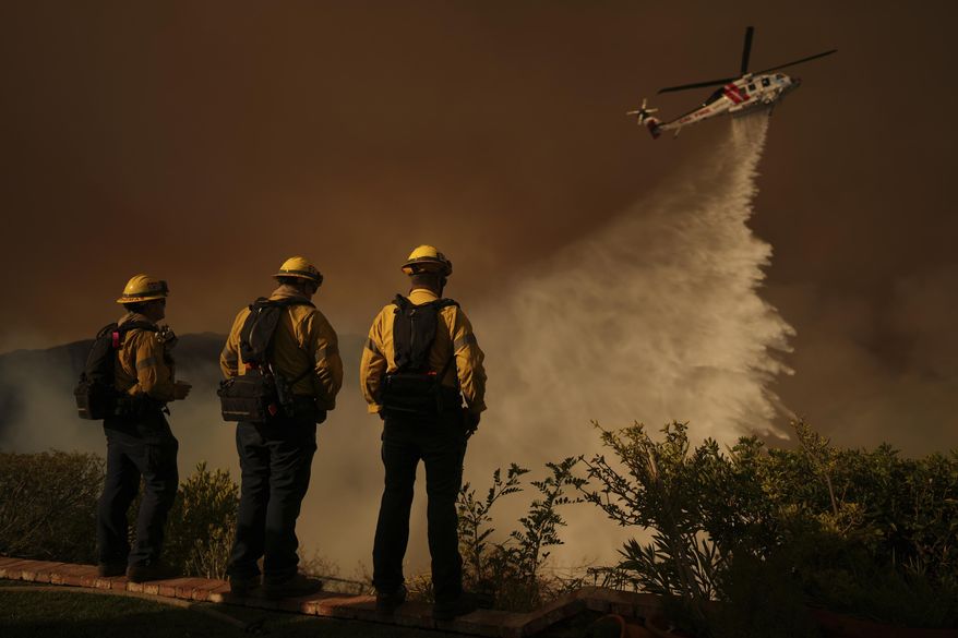 Water is dropped by helicopter on the Palisades Fire in Mandeville Canyon Saturday, Jan. 11, 2025, in Los Angeles. (AP Photo/Eric Thayer)