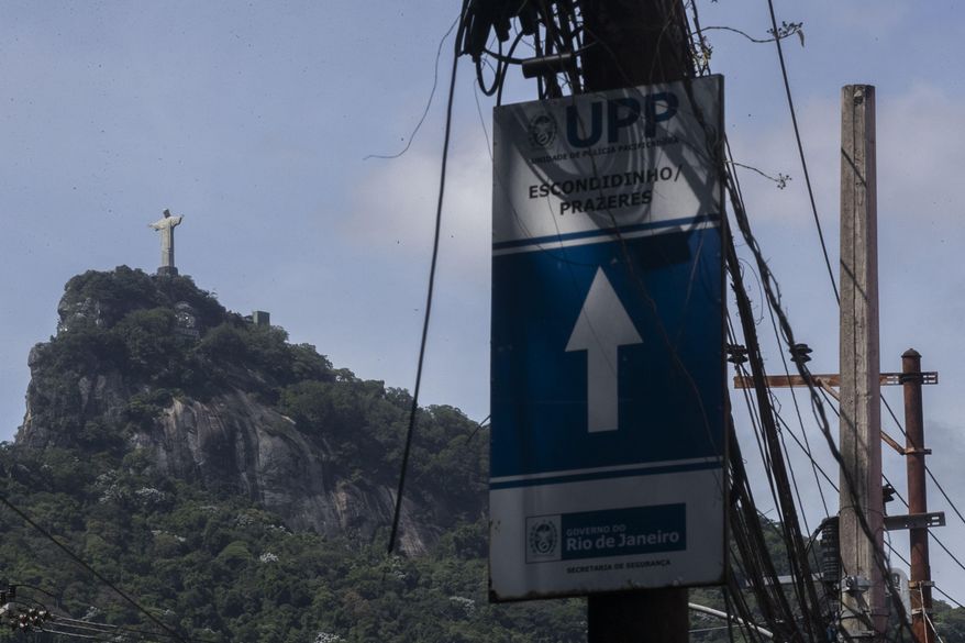 A police station sign hangs on a post near the Christ the Redeemer statue in the favela Morro dos Prazeres, the day after Argentine tourist Gastón Fernando Burlón was shot, in Rio de Janeiro, Friday, Dec. 13, 2024. Burlón was hit in the head and chest after he mistakenly drove his car into this low-income community, according to police, to make his way to visit the statue. (AP Photo/Bruna Prado)