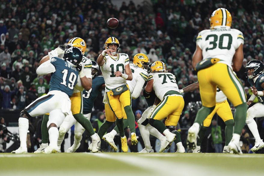 Green Bay Packers quarterback Jordan Love (10) throws the ball to running back Chris Brooks (30) during the second half of an NFL wild-card playoff football game against the Philadelphia Eagles on Sunday, Jan. 12, 2025, in Philadelphia. (AP Photo/Derik Hamilton)