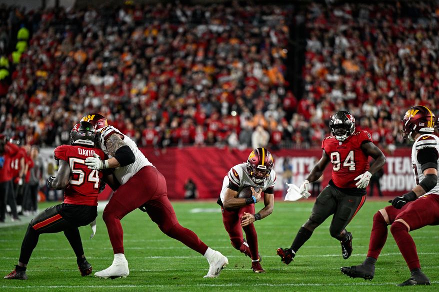 Washington Commanders quarterback Jayden Daniels (5) dives for a four-yard gain on a pivotal 3rd down-and-2 with less than a minute remaining against the Tampa Bay Buccaneers at Raymond James Stadium in Tampa, Florida, January 12, 2025. (Photo by Brian Murphy for the Washington Times)