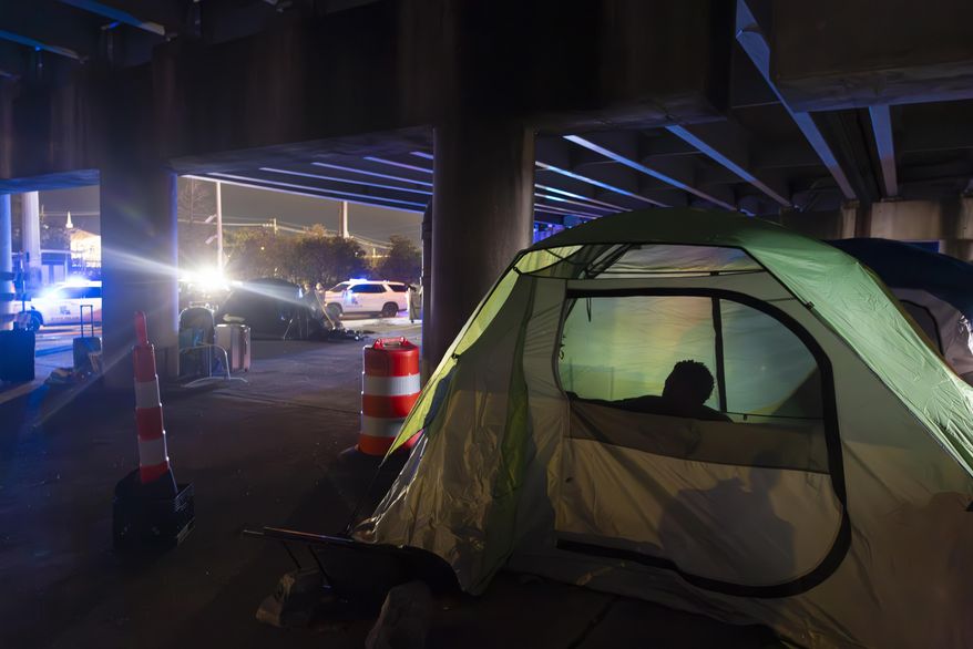 Homeless people wake up in the early morning as Louisiana State Troopers pull up underneath the Pontchartrain Expressway in downtown New Orleans on Wednesday, Jan. 15, 2025. (Chris Granger/The Times-Picayune/The New Orleans Advocate via AP) **FILE**