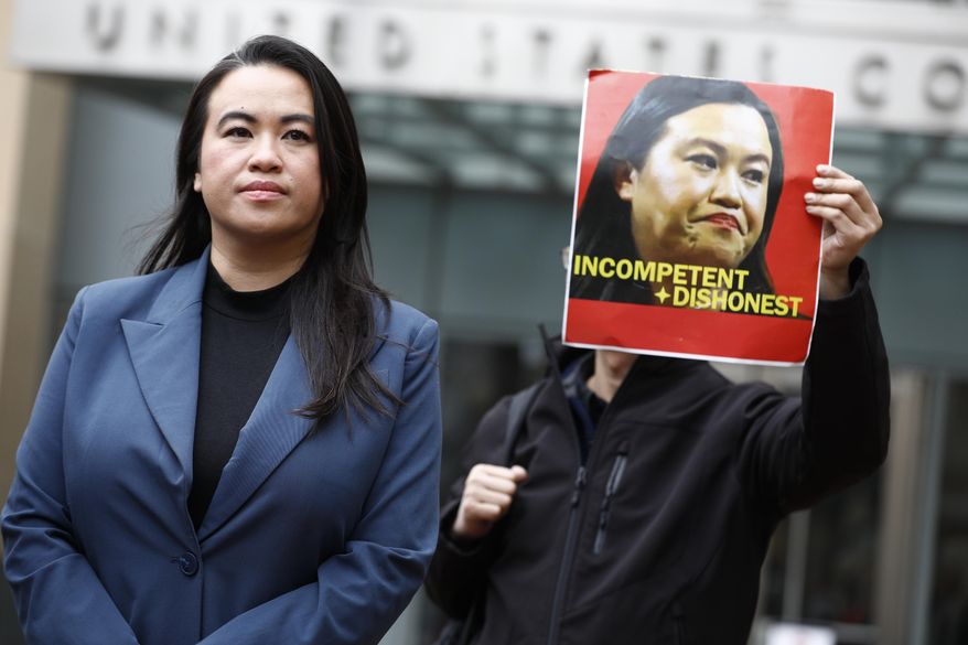 Former Oakland Mayor Sheng Thao stands in front of the United States District Court for a press conference following her arraignment of federal charges in Oakland, Calif., Friday, Jan. 17, 2025, as Tuan Ngo, founder of Asians Unite, protests at right. (Santiago Mejia/San Francisco Chronicle via AP)