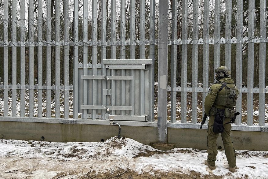 A Polish border guard looks east into Belarus at the crossing point Połowce-Pieszczatka in Polowce, Poland, Thursday, Jan. 16, 2025. (AP Photo/Lorne Cooke)