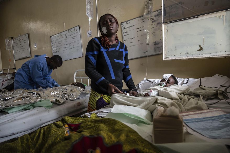 Mariam Nasibu stands by her 10-year-old daughter Deborah, who was wounded in the fighting between M23 rebels and Congolese armed forces, in Goma, Democratic Republic of the Congo, Thursday, Jan. 23, 2025. (AP Photo/Moses Sawasawa)