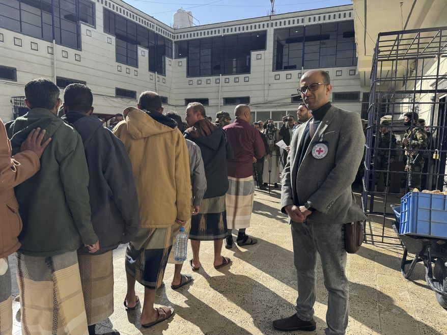 This photo released by the International Committee of the Red Cross shows its officials helping prisoners prepare to be freed by Yemen's Houthi rebels in Sanaa, Yemen, Saturday, Jan. 25, 2025. (International Committee of the Red Cross via AP)