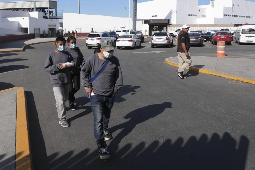 A family walk back into Mexico after being deported at the border crossing in Tijuana, Mexico on Monday, Jan. 20. 2025. The family had been in detention for a week and their deportation was finalized today. (AP Photo/Gregory Bull)