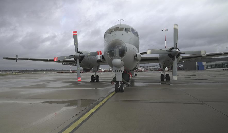 Pilot Lt. Terry (surname withheld by the French military) inspects the wheels of a French Navy Atlantique 2 surveillance plane before its takeoff from Hamburg, Germany, Thursday, Jan. 23, 2025, on a NATO patrol over the Baltic Sea as part of the military's alliance "Baltic Sentry" mission to protect undersea cables and pipelines from sabotage. (AP Photo/John Leicester)