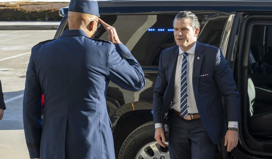 Defense Secretary Pete Hegseth, center, is welcomed to the Pentagon by Chairman of the Joint Chiefs of Staff Gen. Charles Q. Brown Jr., Monday, Jan. 27, 2025 in Washington. (AP Photo/Kevin Wolf)
