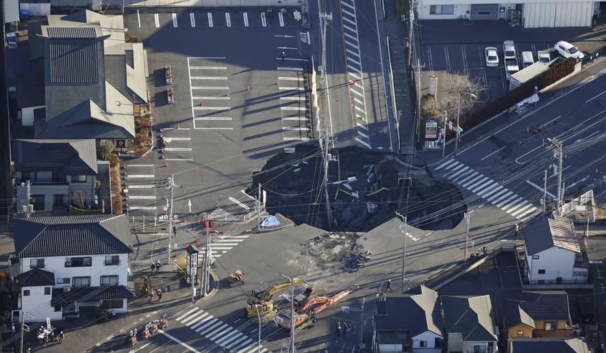 Police officers and rescue members prepare for a rescue mission in Yashio, northeast of Tokyo, Thursday, Jan. 30, 2025, two days after a truck fell into the sinkhole made on a street Tuesday. (Yu Matsuda/Kyodo News via AP)