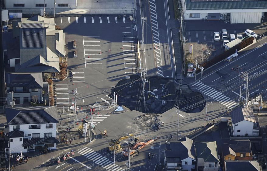 Police officers and rescue members prepare for a rescue mission in Yashio, northeast of Tokyo, Thursday, Jan. 30, 2025, two days after a truck fell into the sinkhole made on a street Tuesday. (Yu Matsuda/Kyodo News via AP)