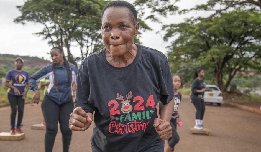 Mellisa Sachitongo, 65, exercises with the Commandos Fitness Club at the Warren Hills cemetery in Harare, Zimbabwe, Saturday, Jan. 18, 2025. ( AP Photo/Aaron Ufumeli)