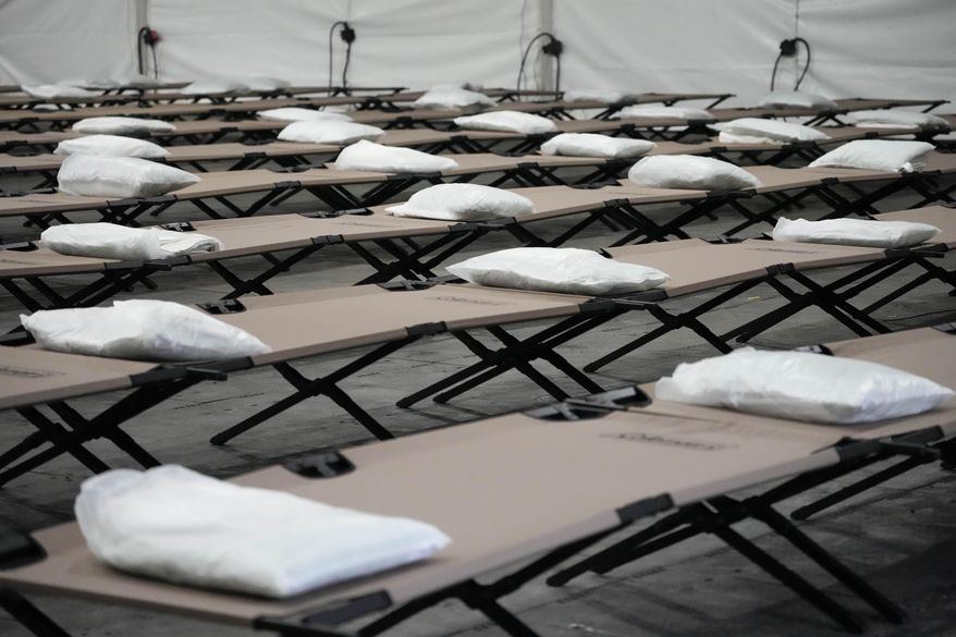 Bags containing bedding are placed on cots inside the dormitory tent during a tour of a shelter New York City that is setting up to house up to 1,000 migrants, in the Queens borough of New York, Aug. 15, 2023. (AP Photo/Mary Altaffer, File)