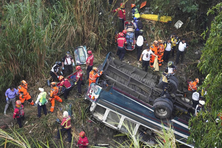 Firefighters work the scene of a fatal bus crash after it fell from a bridge on the outskirts of Guatemala City, Monday, Feb. 10, 2025. (AP Photo/Moises Castillo)