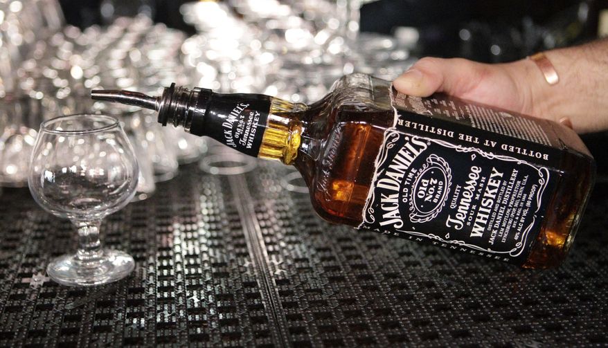 In this March 4, 2011, file photo, a bartender begins to pour a drink from a bottle of Jack Daniels at a bar in San Francisco. (AP Photo/Paul Sakuma, File)