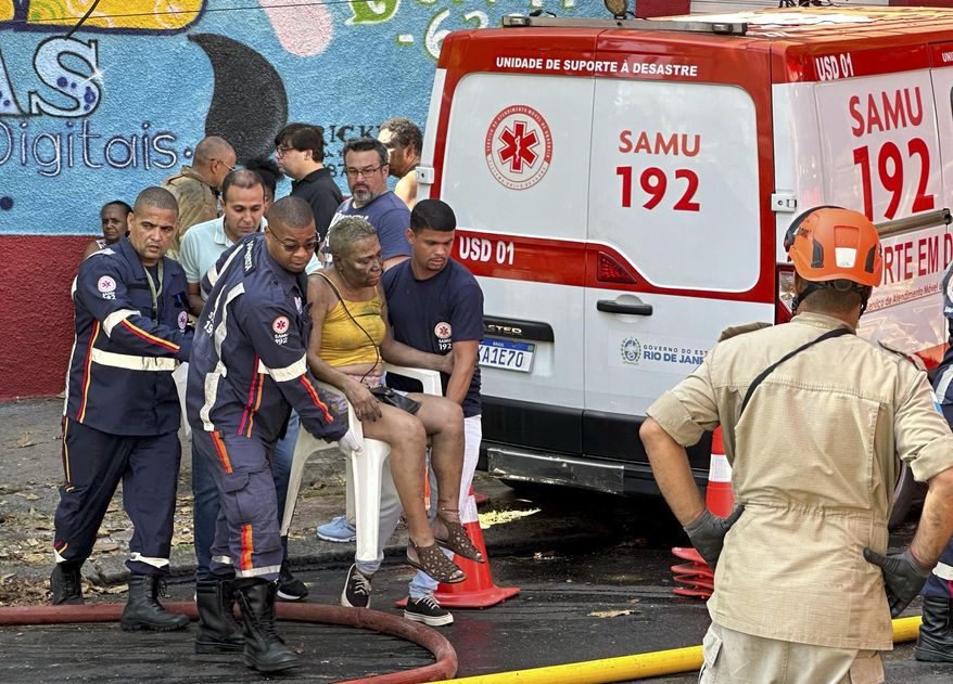 Health workers carry an injured woman after a fire destroyed a factory that produces Carnival costumes for the lower division samba schools in Rio de Janeiro, Wednesday, Feb. 12, 2025. (AP Photo/Diarlei Rodrigues)