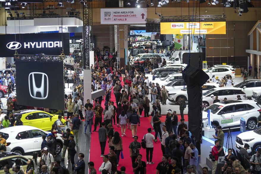 Visitors look at vehicles during the Indonesian International Motor Show in Jakarta, Indonesia, Thursday, Feb. 13, 2025.(AP Photo/Tatan Syuflana)