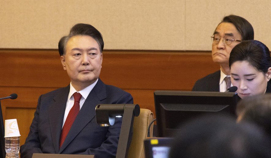 South Korea's impeached President Yoon Suk Yeol, left, attends a hearing of his impeachment trial at the Constitutional Court in Seoul, South Korea, Thursday, Feb. 13, 2025. (Joen Heon-Kyun/Pool Photo via AP)