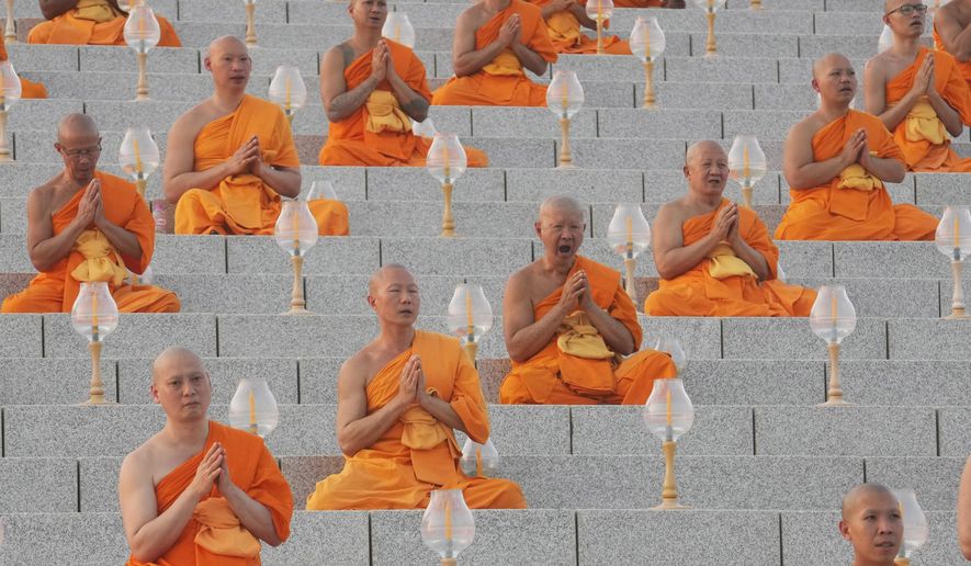 Thai Buddhist monks pray as they gather at Wat Dhammakaya temple to participate in Makha Bucha Day ceremonies in Pathum Thani, Thailand, Tuesday, Feb. 12, 2025. (AP Photo/Sakchai Lalit)