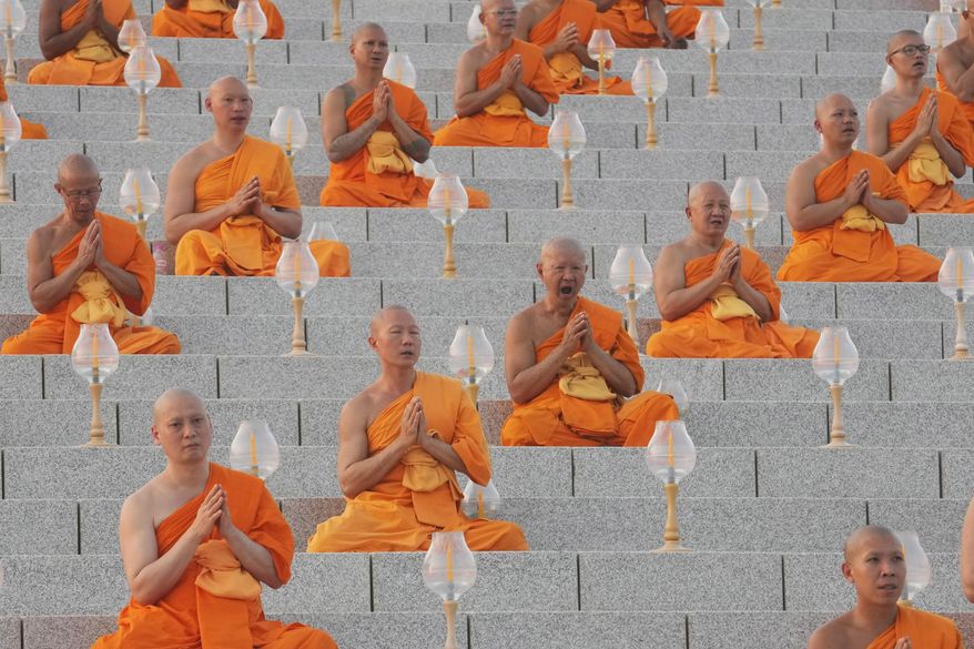 Thai Buddhist monks pray as they gather at Wat Dhammakaya temple to participate in Makha Bucha Day ceremonies in Pathum Thani, Thailand, Tuesday, Feb. 12, 2025. (AP Photo/Sakchai Lalit)