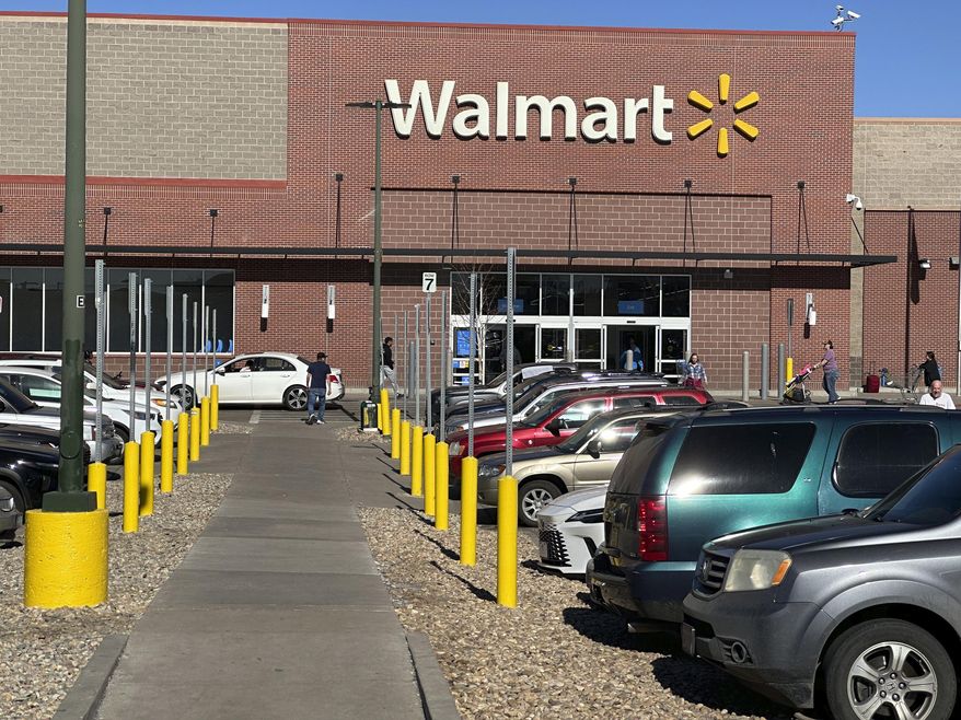 FILE - Shoppers head into and out of a Walmart store, Feb. 7, 2025, in Englewood, Colo. (AP Photo/David Zalubowski, FILE)