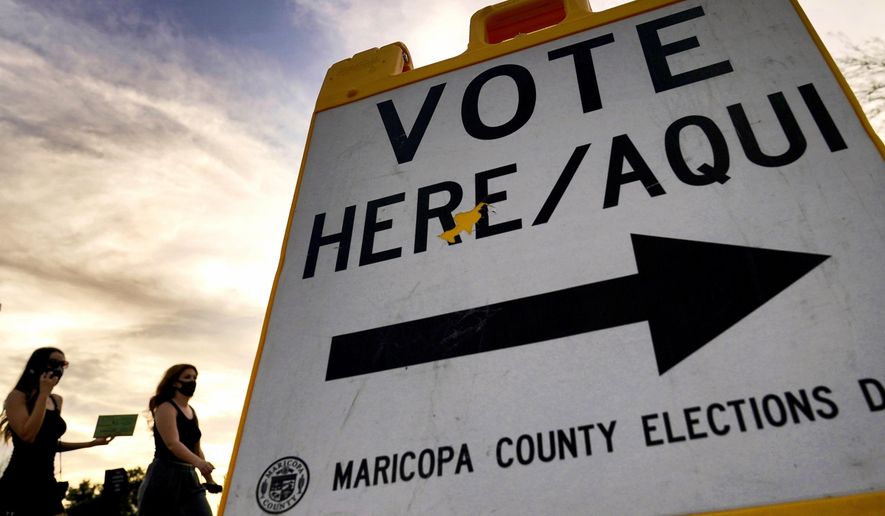 FILE - Voters deliver their ballot to a polling station in Tempe, Ariz., on Nov. 3, 2020. (AP Photo/Matt York, File)