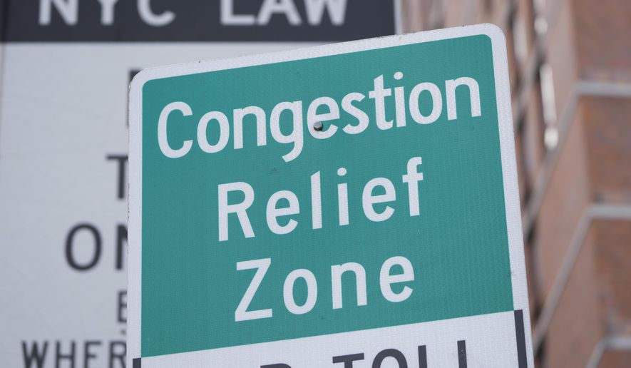 Signs, including some advising drivers of congestion pricing tolls, are displayed near the exit of the Lincoln Tunnel in New York, Wednesday, Feb. 19, 2025. (AP Photo/Seth Wenig)