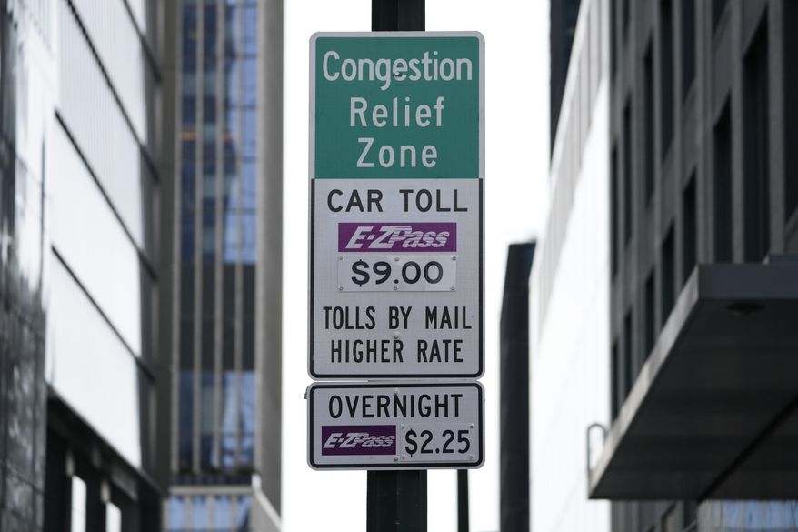 Signs advising drivers of congestion pricing tolls are displayed near the exit of the Lincoln Tunnel in New York, Wednesday, Feb. 19, 2025. (AP Photo/Seth Wenig)