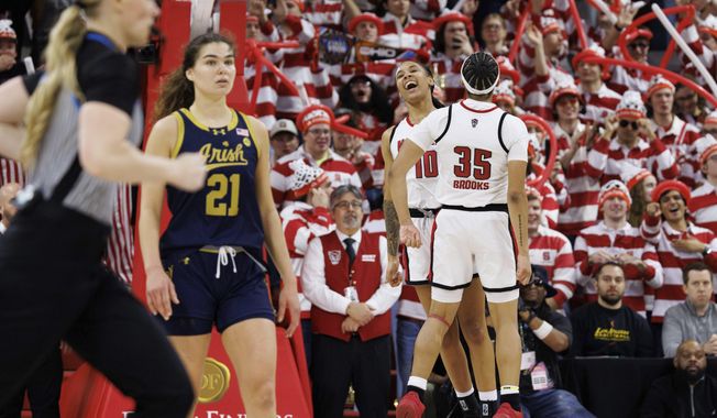 NC State's Aziaha James (10) and Zoe Brooks (35) celebrate behind Notre Dame's Maddy Westbeld (21) in the final moments of double-overtime in an NCAA college basketball game in Raleigh, N.C., Sunday, Feb. 23, 2025. (AP Photo/Ben McKeown)