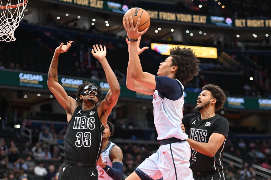 Washington Wizards forward Kyshawn George (18) putting the ball up as Brooklyn Nets center Nicolas Claxton (33) tries to defend during the first quarter of an NBA game at Capital One Arena in Washington D.C., February 24, 2025. (Photo for the Washington Times)