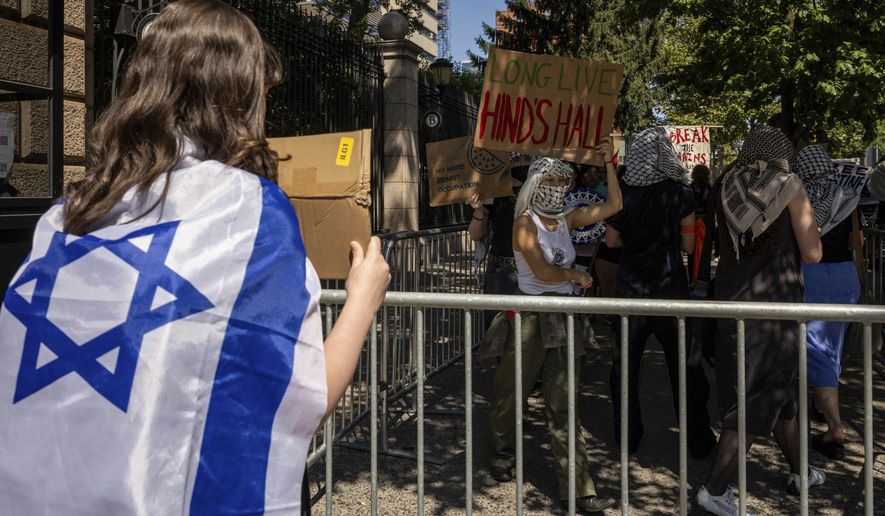 A pro-Israel student holds a sign while pro-Palestinian supporter hold picket line outside Barnard College, Tuesday, Sept. 3, 2024, in New York. (AP Photo/Yuki Iwamura)