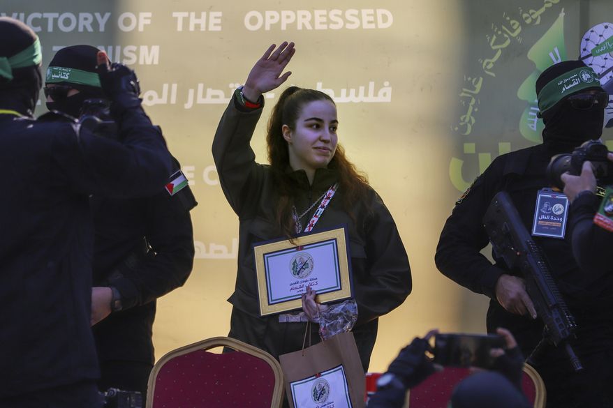 Israeli soldier Agam Berger waves to the crowd as she is handed over to the Red Cross by masked Islamic Jihad militants at the Jabalya refugee camp in Gaza City, Thursday Jan. 30, 2025.(AP Photo/Mohammed Hajjar)