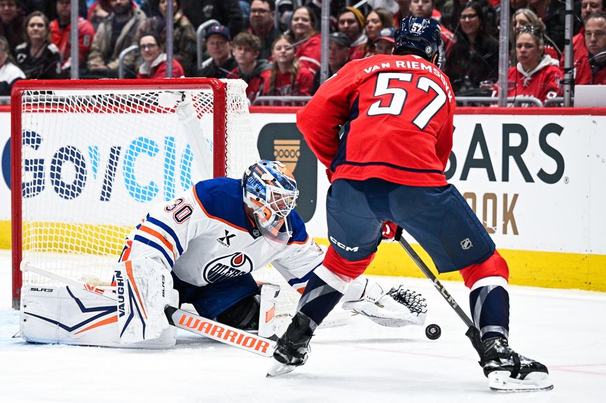 Edmonton Oilers goalie Calvin Packard (30) scrambles to cover a puck as Washington Capitals defenseman Trevor van Riemsdyk (57) closes in on him at Capital One Arena, Washington, D.C., February 23, 2025. (Photo by Brian Murphy for the Washington Times)